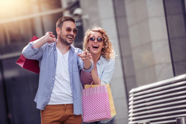 快乐的情侣走在城市购物后的五颜六色的袋子 — 图库照片