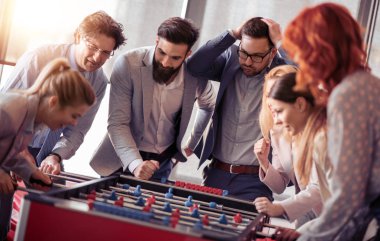 Modern ofis masa futbolu oynayan arkadaşları