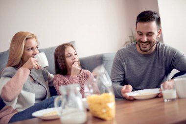 mutlu anne, baba ve kızı evde kahvaltı