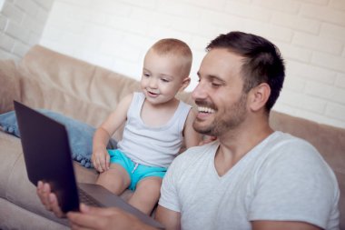 mutlu baba ve küçük oğlu laptop çizgi film izlerken 