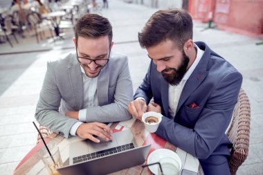 Kafede dizüstü bilgisayar üzerinde çalışan iki iş adamları