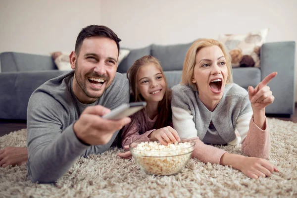 Padre Madre Hija Tumbadas Suelo Comiendo Palomitas Maíz Viendo Televisión —  Fotos de Stock