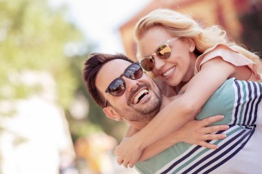 Onun kız arkadaşı uzanmış silah tutarken piggybacking neşeli genç adam.