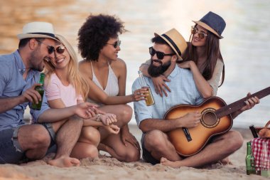 Neşeli gençlerle eğlenmek sahilde gitar. Yaz, insanlar, arkadaşlık, eğlence ve tatil kavramı.
