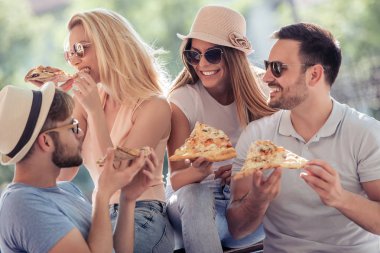 dört genç neşeli insanlar Pizza yemek