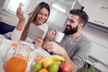 Tablet izliyor ve kahvaltı Yong sevgi dolu Çift.