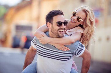 Onun kız arkadaşı uzanmış silah tutarken piggybacking neşeli genç adam.