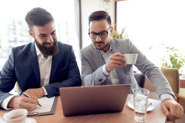 Gülümseme onay iş laptop Office ile iki emin işadamları.