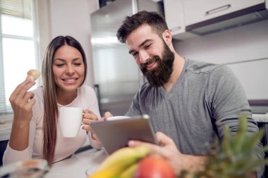 Tablet izliyor ve kahvaltı Yong sevgi dolu Çift.