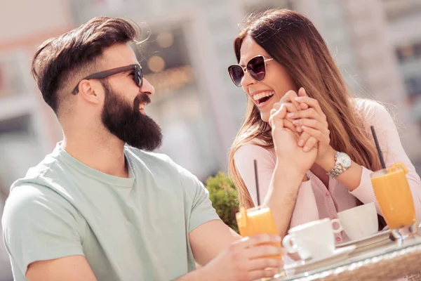 Young cheerful man and woman dating and spending time together in cafe.