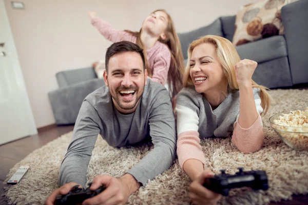 Playful family playing video games together in a living room.