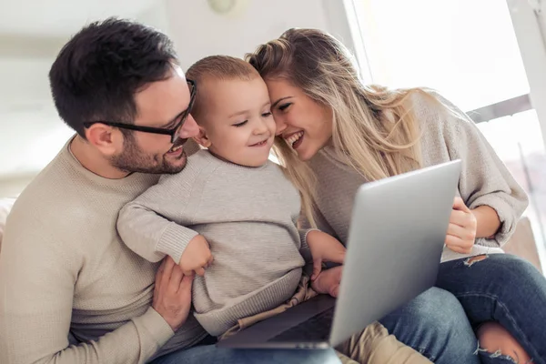 Bela Família Jovem Usando Laptop Falando Sorrindo Enquanto Sentado Sofá — Fotografia de Stock