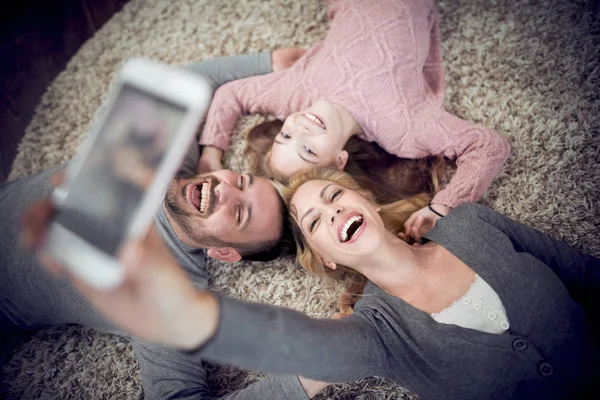 Top View Happy Young Family Smiling Camera Take Selfie Lying — стоковое фото