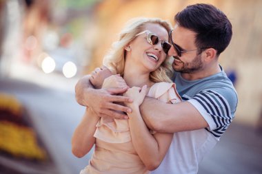 Mutlu genç çift dışarıda eğleniyor ve gülümsüyor..