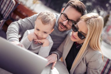 Laptop bir şey izlerken neşeli genç Aile.