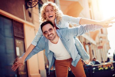Mutlu genç çift dışarıda eğleniyor ve gülümsüyor..