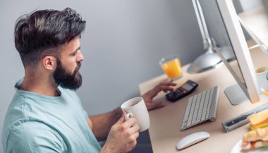 Genç adam evde onun bilgisayar üzerinde çalışan.