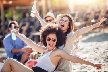 İki genç kadın arkadaş sahilde eğleniyor. Yaz tatil, insanlar, arkadaşlık, eğlence ve tatil kavramı.
