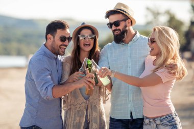 Sahilde parti mutlu gençler. Yaz tatil, insanlar, arkadaşlık, eğlence ve tatil kavramı.