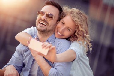 Mutlu genç çift dışarıda eğleniyor ve gülümsüyor..