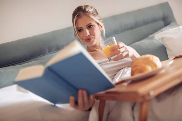 Vakker Kvinne Som Spiser Frokost Sengen Leser Bok – stockfoto