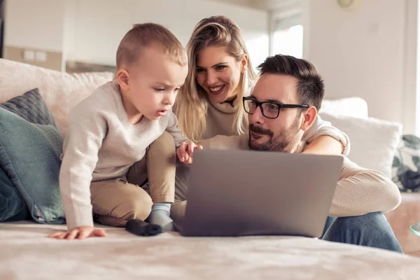 Bela Família Jovem Usando Laptop Falando Sorrindo Enquanto Sentado Sofá — Fotografia de Stock