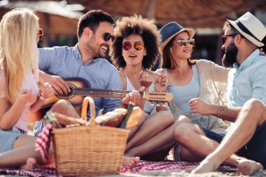 Arkadaşlar eğlenmeye sahilde gitar ile grup. Yaz, tatil, tatil, müzik, insanlar kavramı.