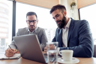 Bir gülümseme onay iş ofiste laptop ile iki iş adamı.