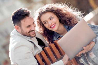 Dizüstü bilgisayar ile şehrin geri kalan sahip güzel romantik çift.