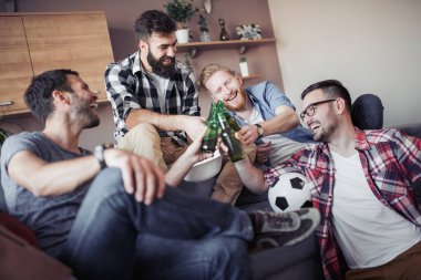 Mutlu erkek arkadaşlar futbol maçı izlerken bira içmek.