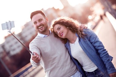 Güzel romantik çift bir akıllı telefon kullanarak ve selfie yaparken gülümseyen.