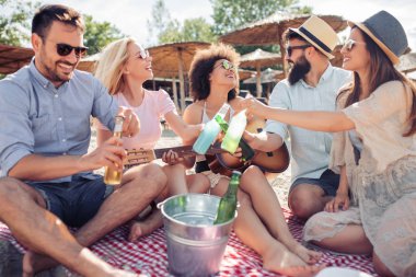 Arkadaşlar eğlenmeye sahilde gitar ile grup. Yaz, tatil, tatil, müzik, insanlar kavramı.