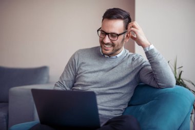 Genç adam üstünde Laptop evde çalışma office.