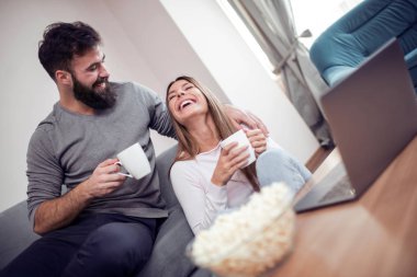 Genç mutlu çift çalışma ya da sahip eğlenceli birlikte, bilgisayar başında oturma odası ile online alışveriş için internet kullanımı.