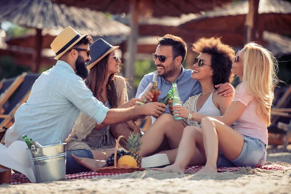 Sahilde bira şişeleri alarak arkadaş grubu.