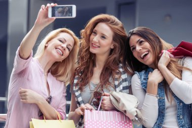 Üç güzel genç kadın akıllı telefon ile bir selfie alarak güneş gözlüğü.