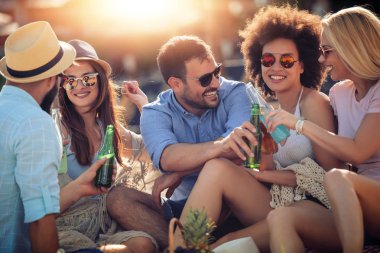 Eğleniyor ve sahilde bira içme arkadaşlar. Yaz tatili, insanlar, eğlence ve tatil kavramı.