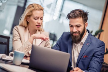 Modern ofiste yeni bir proje üzerinde çalışan iki iş arkadaşı.