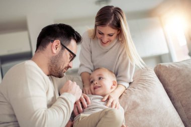 Neşeli genç aile evde iyi vakit geçiriyor.