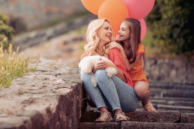 Neşeli anne ve kızı parkta eğleniyor.