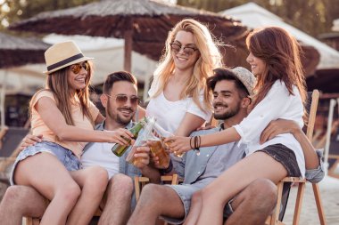 Bira içme ve müzik dinleme arkadaşlar beach partide eğleniyor. Yaz, tatil, tatil, müzik, mutluluk ve insanlar kavramı.