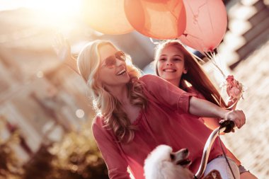 Anne ve kızı şehirde, eğleniyor Bisiklete binmek. 