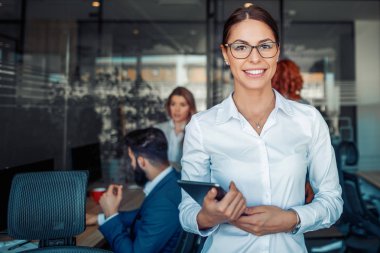 İş kadın ofiste iş arkadaşları önünde tablet kullanma. İş, insanlar, ekip çalışması ve office kavramı.