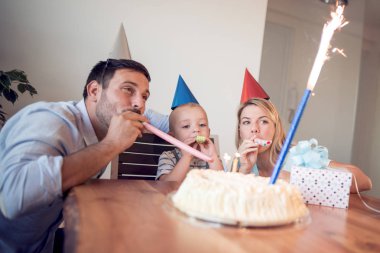 Küçük çocuk Doğum günü pastası partide mum dışarı darbeler. Mutlu aile kutluyor Doğum günü.