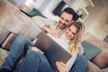 Genç çift birlikte vaktinizi dizüstü evde, kullanma portresi.