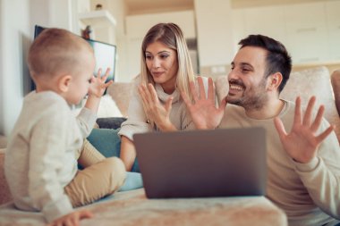 Gülümseyen Genç Anne ve odaklanmış oğlu dizüstü evde kullanma.
