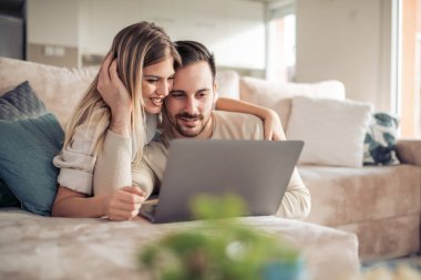 Genç çift birlikte vaktinizi dizüstü evde, kullanma portresi.