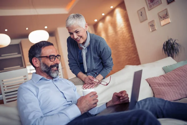 Üst düzey bir çift evde bir dizüstü bilgisayar ile portresi.