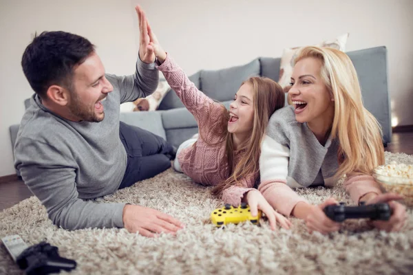 Happy family  playing video game on floor at home.