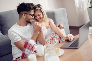 Evde Kahvaltı, pasta yeme, içme sütü, sarılma ve bir dizüstü bilgisayar üzerinde çalışan çift.